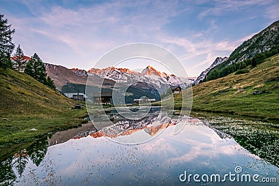 Crimson Sunset over Dent-Blanche Snowy Mountain Reflecting in Arbey Lake in Valais. Stock Photo