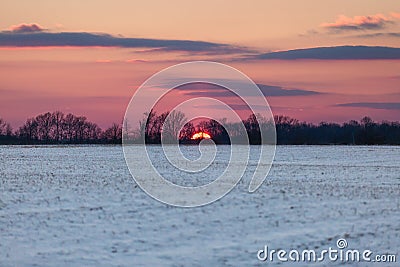 Crimson Sunset over Snowy American Corn Fields in Winter with Bl Stock Photo