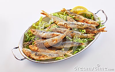 Crisp fried sardines in batter on fresh lettuce Stock Photo
