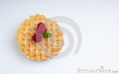 Crispy Belgian waffles with raspberry berries and mint leaves on a white textured surface Stock Photo