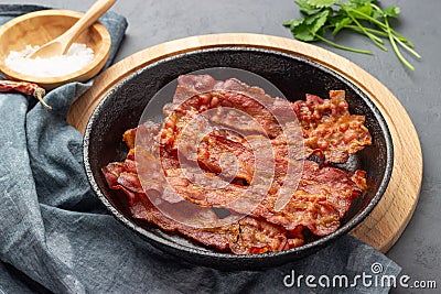 Crispy fried bacon in a cast iron pan. Stock Photo