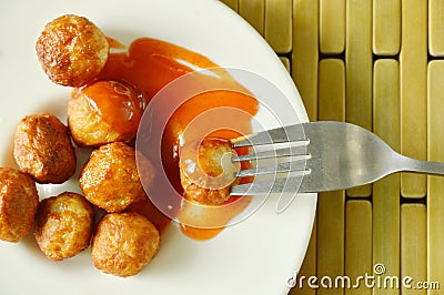 Crispy fried pork ball dressing chili sauce stabbing in fork Stock Photo