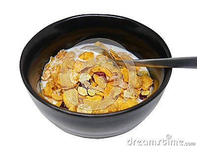 Crispy and healthy organic breakfast cereal flakes with red dried cranberry and cold soy milk in dark black handmade pottery bowl Stock Photo