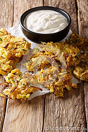 crispy Onion Bhajis vegan snack or starter with yogurt close-up. Vertical Stock Photo