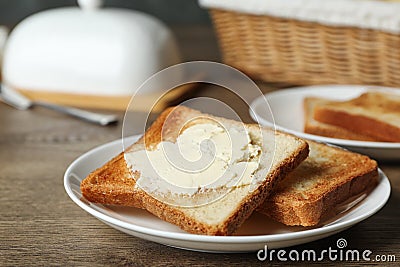 Crispy toasted bread with butter on wooden table Stock Photo