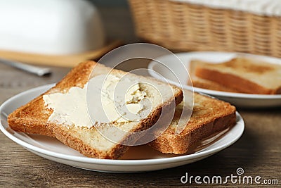 Crispy toasted bread with butter on wooden table Stock Photo