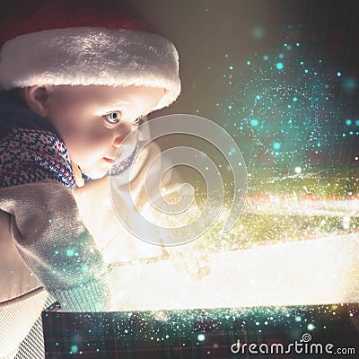 Cristmas baby holding gift with abstract fairy dust, stardust. Christmas Stock Photo