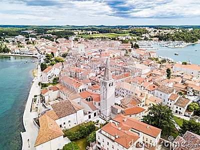 Croatian town of Porec, shore of blue azure turquoise Adriatic Sea, Istrian peninsula, Croatia. Bell tower, red tiled roofs. Stock Photo