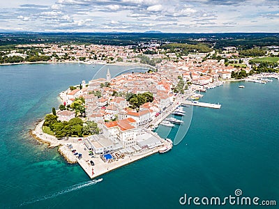 Croatian town of Porec, shore of blue azure turquoise Adriatic Sea, Istrian peninsula, Croatia. Bell tower, red tiled roofs. Stock Photo