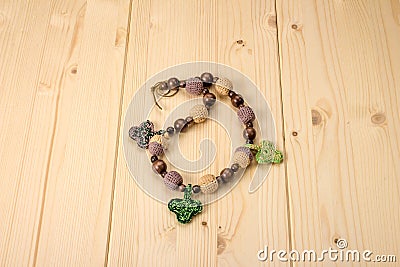 Crochet baby handmade beads with acorns and leaves on a wooden t Stock Photo
