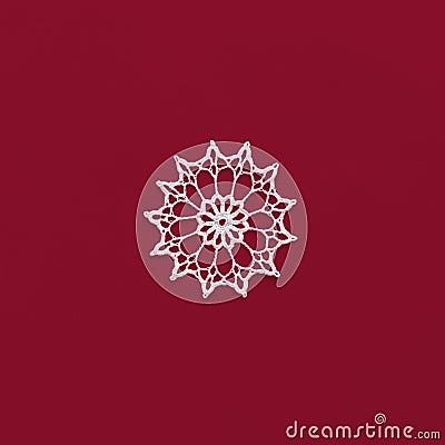 Crochet snowflake isolated on red. Handmade decorative knitted doily snowflake. Winter or Christmas decoration. Square Stock Photo