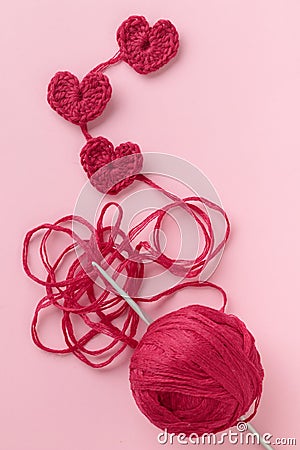 Crocheted amigurumi pink heart with crochet hook and skein of yarn on a pink background. Valentine's day banner Stock Photo