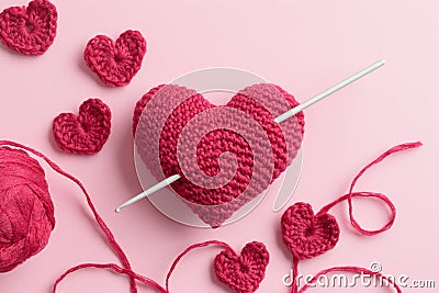 Crocheted amigurumi pink heart with crochet hook and skein of yarn on a pink background. Valentine's day banner Stock Photo