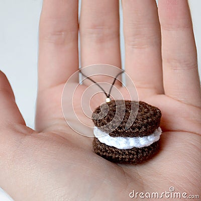 Crocheted brown cookies with a layer of white cream. Keychain on Stock Photo