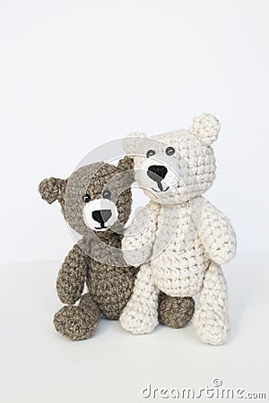 Crocheted gray and brown bears on a white background. Crocheted toy. Stock Photo