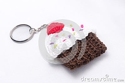 Crocheted keychain in the shape of a vanilla and raspberry cupcake Stock Photo