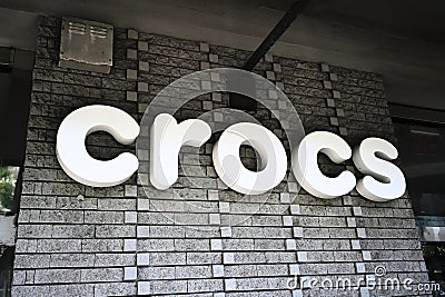 Crocs footwear company logo signage on store in popular Waikiki tourist destination. Editorial Stock Photo