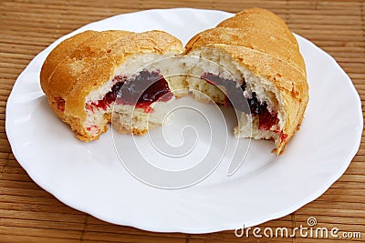 Croissant broken half-and-half on a plate Stock Photo
