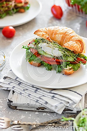 Croissant fish and poached egg sandwich Stock Photo