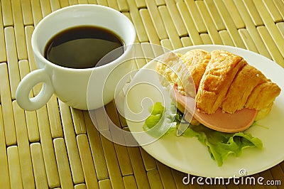 croissant stuffed pork bologna and green oak with black coffee Stock Photo