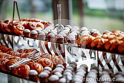 Croissants, muffins and buns lying on a glass table. Stock Photo