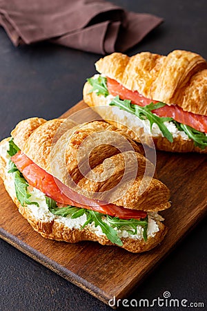 Croissants with salmon, white cheese and arugula. Breakfast Stock Photo