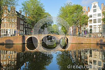 Crooked and colorful heritage buildings and a bridge, overlooking Herengracht canal with perfect reflections, Amsterdam Editorial Stock Photo