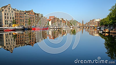 Crooked and colorful heritage buildings and houseboats, overlooking Amstel river with perfect reflections Stock Photo