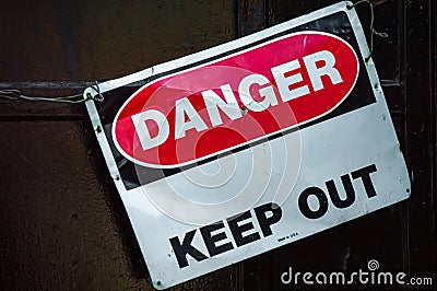 Crooked old metal warning sign that reads DANGER KEEP OUT. Copy space. Stock Photo
