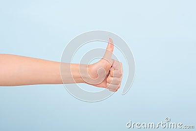 Crop female hand with bright manicure holding thumb up Stock Photo