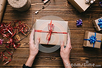 Crop hands holding wrapped present on table Stock Photo