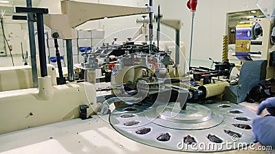 Crop hands putting sweets into wrapping machine. Hands of unrecognizable female worker putting chocolate candies into Stock Photo