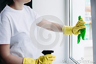 Crop of housewife cleaning dirty window. Concept of housework and apartment service. Stock Photo