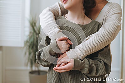 Crop portrait of mother middle age woman and daughter teenager together in the light interior Stock Photo