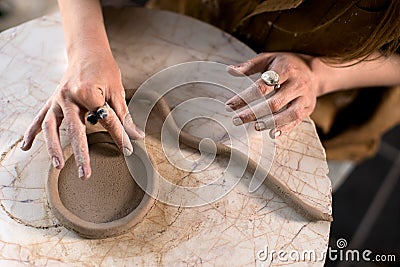 Crop potter making coil vessel on marble table in workshop Stock Photo