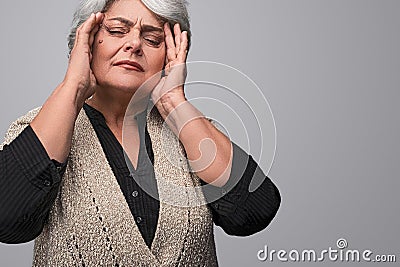 Elderly woman rubbing temples Stock Photo