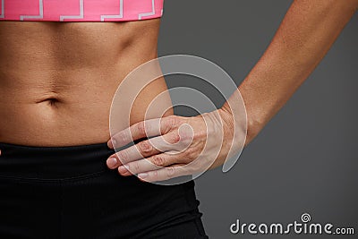 cropped close up body of fit woman wearing shorts and sport top showing slim beautiful stomach and abs in diet fitness Stock Photo