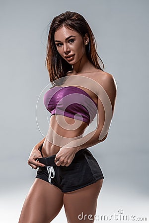 Cropped close up body of fit woman wearing shorts and sport top showing slim beautiful stomach and abs in diet fitness Stock Photo