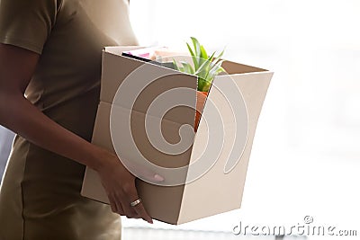 Cropped closeup image african female holding carton box with belongings Stock Photo