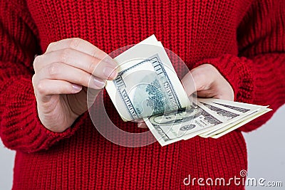 Cropped close up photo of hands of worker counting paper money going to spend all her wage in one day wearing bright knitted Stock Photo