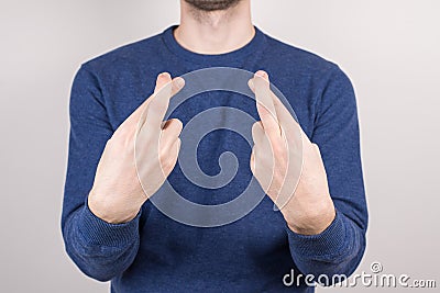 Cropped close-up photo portrait of unsure unconfident guy making crossed finger isolated grey background Stock Photo