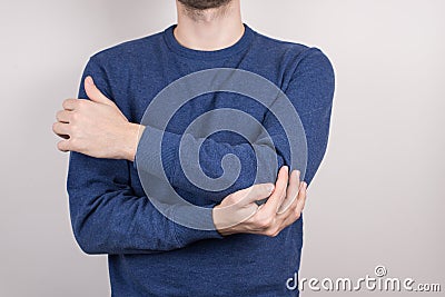 Cropped close-up photo studio portrait of unhappy unsatisfied guy holding touching elbow isolated grey background Stock Photo