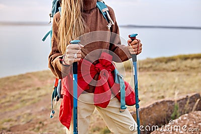 cropped female tourist with trekking poles.beautiful river landscape in the background Stock Photo