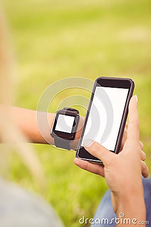 Cropped hands of person wearing smart watch and holding smartphone Stock Photo