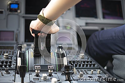 Cropped hands of pilot flying a commercial airplane, cockpit view close up of hands. Captain hand accelerating on the throttle in Stock Photo