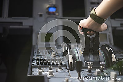 Cropped hands of pilot flying a commercial airplane, cockpit view close up of hands. Captain hand accelerating on the throttle in Stock Photo