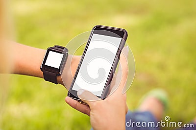 Cropped hands wearing smart watch and holding smartphone Stock Photo