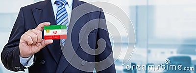 Cropped image of businessman holding plastic credit card with printed flag of Iran. Background blurred Stock Photo