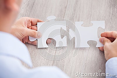 Cropped image of businessman joining jigsaw pieces Stock Photo