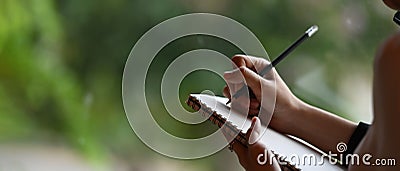 Cropped image of a businesswoman`s hand is taking notes. Stock Photo